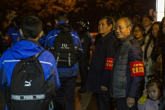 “爱心护学队”成员正在巴南区龙洲湾中学门口护学。