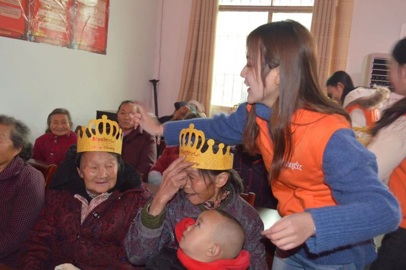 志愿者为老人们带上生日帽。
