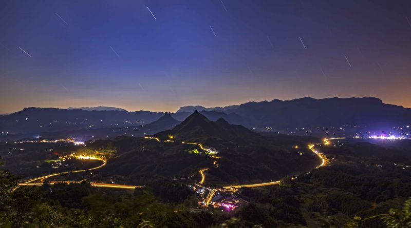 【我爱我的祖国】乡村龙图腾 夜色中的重庆市南川区大有镇，天空星光闪烁，乡村公路上与高速路上的车的灯光轨迹交相辉映，宛若盛世图腾。张文强 摄