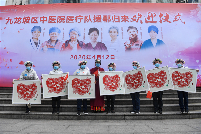 市级剪纸大师杨艺向医疗队成员赠送“提灯女神”剪纸。（九龙报社 记者 陈林 摄