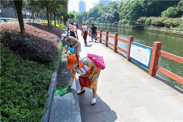 一配  6月19日，杨家坪街道“保护母亲河，杨街在行动”举办，志愿者在桃花溪动物园段开展江边垃圾捡拾活动。（九龙报社 记者 陈林 摄