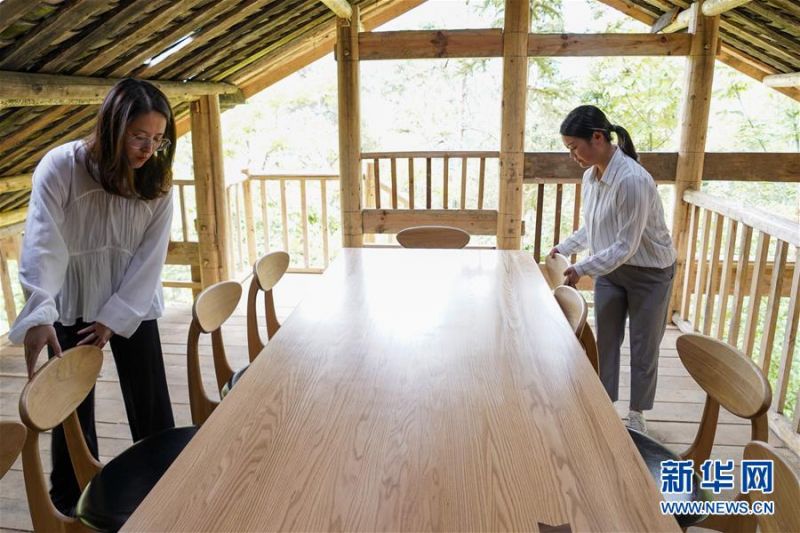　在城口县北屏乡松柏村，工作人员在一个利用闲置木屋老房改建的民宿内整理桌椅（5月28日摄）。　　近年来，地处秦巴山国家集中连片特困地区的重庆城口县结合实际因地制宜发展乡村旅游产业。截至目前，该县已开设“大巴山森林人家”品牌乡村旅游民居民宿1800余家、接待床位达到2万多张，带动当地农村2000余户、8000余人实现增收致富。　　新华社记者 刘潺 摄