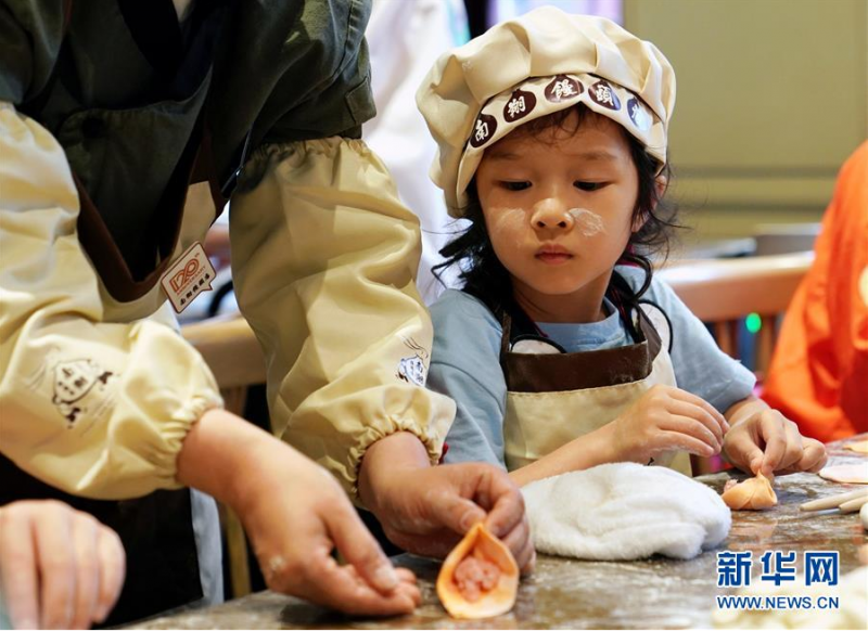 5月30日，小朋友在学习小笼包的包捏方法。新华社记者 刘颖 摄