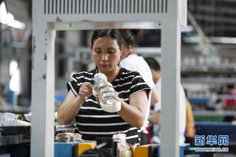 　　6月18日，在重庆市奉节县安坪镇弘源鞋业扶贫车间，工人在生产线上贴鞋后跟标。 近年来，重庆市奉节县安坪镇利用场地、劳动力等优惠政策，逐步建设三期扶贫车间7700平方米，发展制伞、制鞋、制衣等企业9家，累计带动贫困户100余人在家门口就业，实现脱贫增收。 新华社记者 黄伟 摄