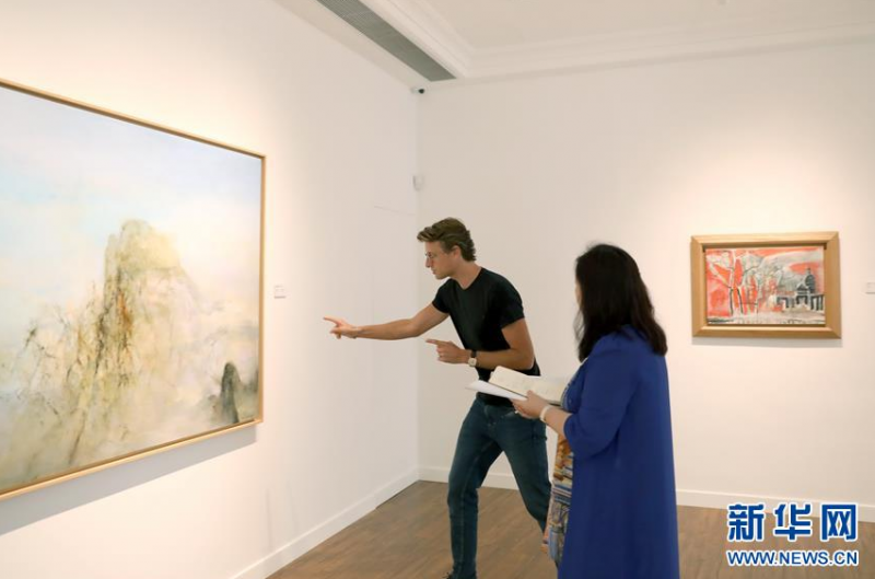 维尔潘画廊主人潘雅德（左）在讲解赵无极的画作（6月19日摄）。 为纪念赵无极100周年诞辰而举办的“赵无极：友谊与融合”画展正在香港维尔潘画廊举行，展示了赵无极不同时期的多幅作品。 新华社记者 吴晓初 摄