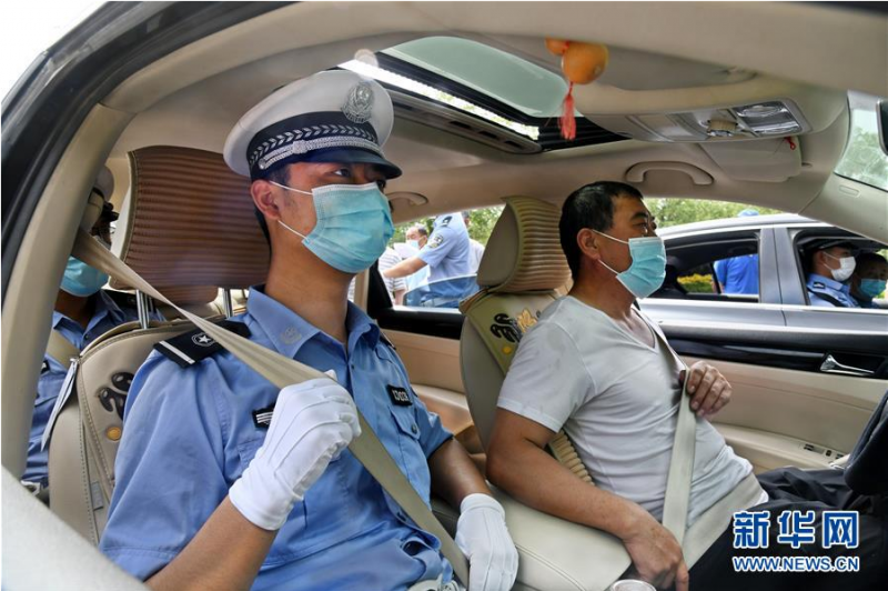 6月9日，青岛高新区交警大队民警在宣传活动上示范安全带的规范使用方法及要求。　　连日来，青岛交警部门通过进企业、进社区、进工地等形式，持续开展“一盔一带”守护生命宣传活动。宣传结合典型道路交通事故案例，讲解驾乘摩托车不按规定佩戴安全头盔、驾驶汽车不系安全带的危险后果，进一步提升摩托车、电动自行车骑乘人员和汽车驾乘人员安全防护意识。　　新华社记者 李紫恒摄