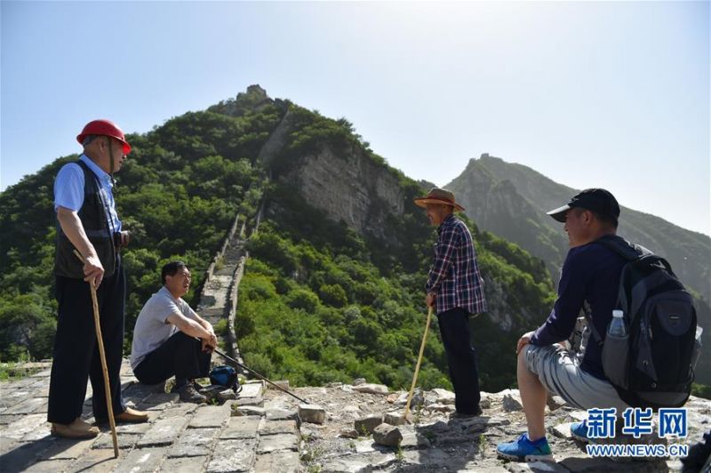 程永茂(左一)和同事在进入修缮工程作业面之前讨论当日工作事宜(6月3日摄)。新华社发(陈钟昊摄)