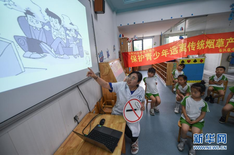 5月28日，夹浦镇卫生院的医生给夹浦镇中心幼儿园的孩子上课，进行世界无烟日的主题宣讲。 当日，为了迎接即将到来的世界无烟日，浙江省长兴县夹浦镇中心幼儿园开展了“保护幼儿，远离烟草，健康生活”主题宣讲活动。夹浦镇卫生院的医生结合真实案例向孩子们宣讲无烟日的意义，普及健康生活理念。孩子们还用画笔一起设计了“禁止吸烟”的标志与“无烟日小海报”。 新华社记者 徐昱 摄