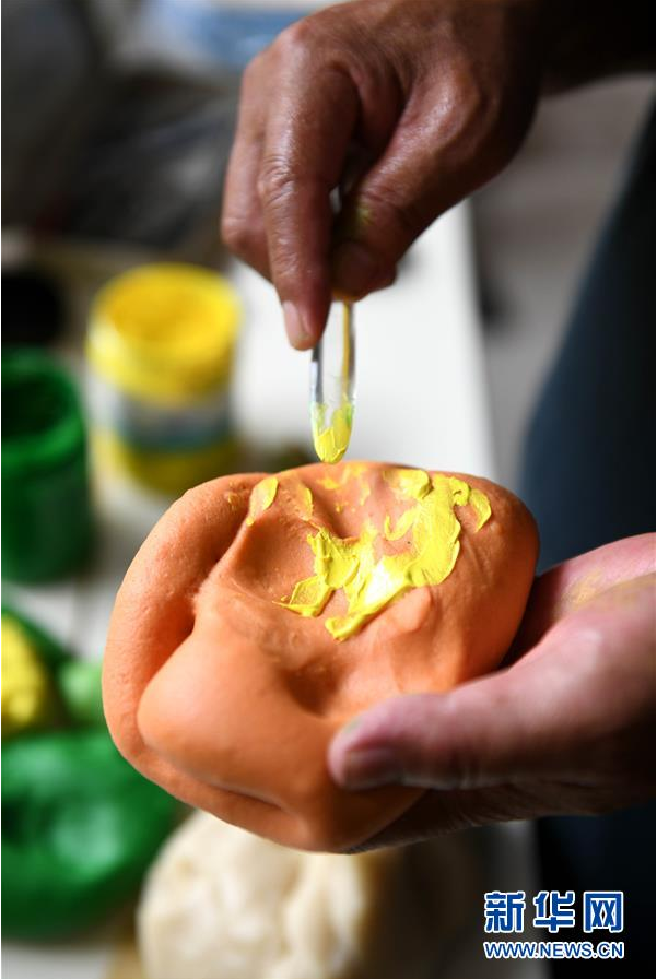 6月11日，在河北省石家庄市深泽县职业技术教育中心，民间艺人王亮在进行面塑掺色流程。 深泽面塑是当地有名的民间手工技艺，传承历史悠久。石家庄市深泽县民间艺人王亮自幼酷爱手工，他专注面塑创作20多年，推出历史神话人物、十二生肖、田园风光等作品。近年来，王亮致力于传承面塑民间技艺，将其带到20多个国家和地区进行文化交流，让更多人接触、了解到中国传统民间艺术。 新华社发（许建园 摄）