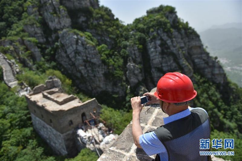 程永茂用相机记录箭扣长城的修缮情况(6月3日摄)。新华社发(陈钟昊摄)