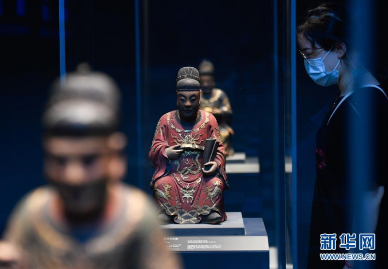 6月12日，观众在奉化博物馆观看朱金漆木雕坐像。 当日，主体建筑由原热电厂发电车间改造而来的浙江省宁波市奉化博物馆首次向公众开放。该博物馆建筑保留了原热电厂的柱梁等钢结构体系和煤斗、耐火砖等工业遗存，带有浓厚的工业风。展厅面积约6000平方米，由3个常设展厅和5个临时展厅组成，目前基本陈设的文物达3000多件。 新华社记者 黄宗治 摄