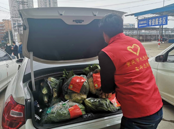 青年志愿者正在把“暖心套餐”搬上车，送往防疫一线医护人员家中。