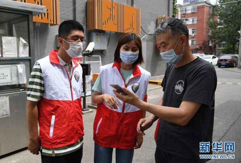 6月8日，在北京市海淀区中关村街道西里社区，社区工作人员（左一、左二）在高温中值守岗位。 北京市预警中心、北京市气象台6月6日发布今年夏天首个高温预警信号，预警等级为“蓝色预警”。7日至8日，北京市大部分地区持续高温。 新华社记者 任超 摄