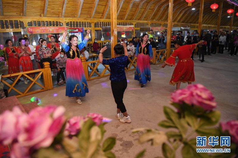 在新疆于田县兰干乡兰干夜市，文化能人与村民在一起跳舞（5月20日摄）。 新华社记者 沙达提 摄