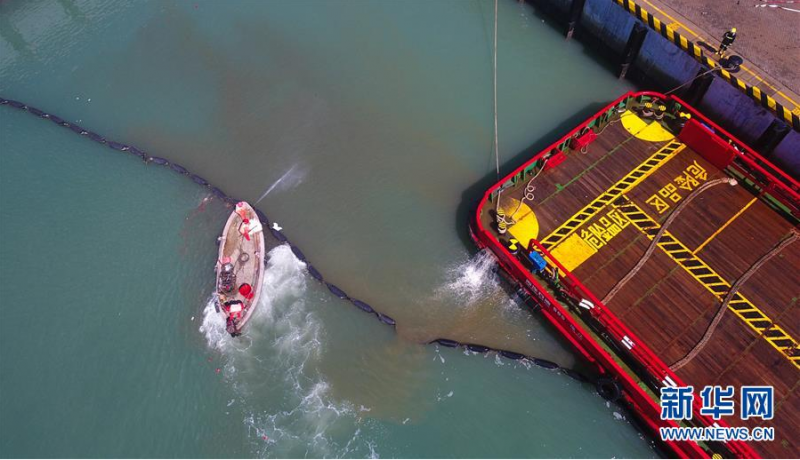 6月12日,在海口港马村港区危险品船舶船岸应急联合演习现场,工作人员在清除海面污物(无人机照片)。 当日,海口海事局在海口港马村港区组织开展危险品船舶船岸应急联合演练。本次演练通过模拟设置一艘危险品船舶在码头作业过程中发生泄漏事故导致海域污染、船舶起火、人员受伤的场景,演练危险品码头及相关单位部门的应急处置与协作反应,提升危险品码头应急处置能力。 新华社记者 杨冠宇 摄