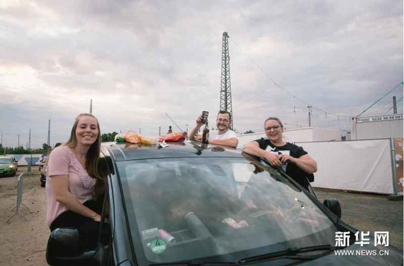 6月13日,观众在德国波恩市坐在车上观看汽车音乐会。新华社发(唐颖摄)