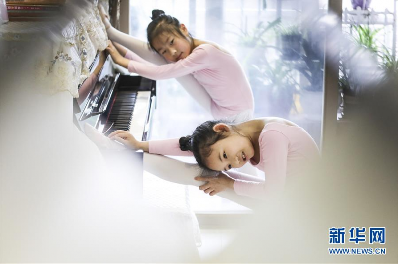 图为5月31日，朱皓嫡（前）与陈熙妍在进行拉伸，准备练舞。 新华社记者欧东衢摄