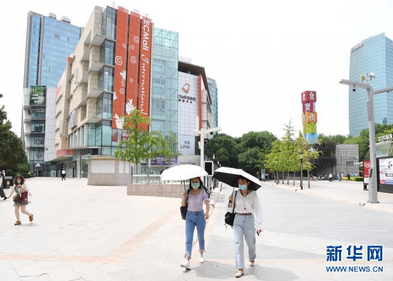 6月8日，在位于北京市海淀区的中关村步行街，行人用遮阳伞遮挡阳光。 北京市预警中心、北京市气象台6月6日发布今年夏天首个高温预警信号，预警等级为“蓝色预警”。7日至8日，北京市大部分地区持续高温。 新华社记者 任超 摄