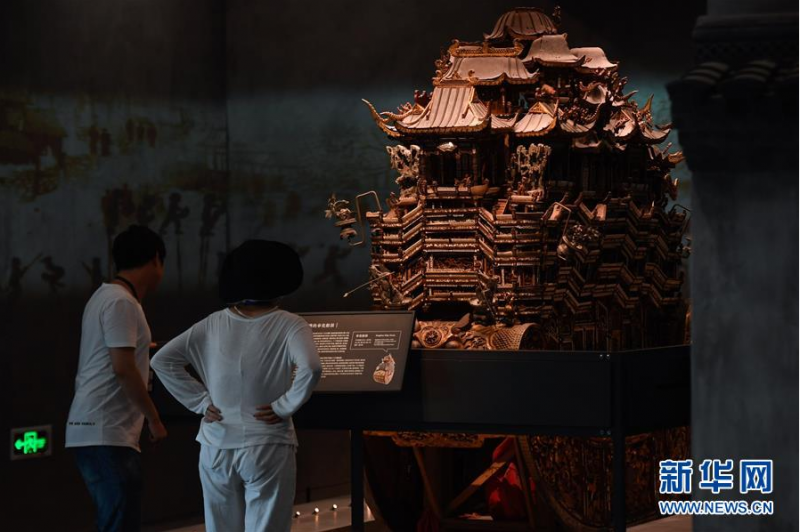 6月12日，观众在奉化博物馆观看一座由木工打制而成的奉化船鼓。 当日，主体建筑由原热电厂发电车间改造而来的浙江省宁波市奉化博物馆首次向公众开放。该博物馆建筑保留了原热电厂的柱梁等钢结构体系和煤斗、耐火砖等工业遗存，带有浓厚的工业风。展厅面积约6000平方米，由3个常设展厅和5个临时展厅组成，目前基本陈设的文物达3000多件。 新华社记者 黄宗治 摄