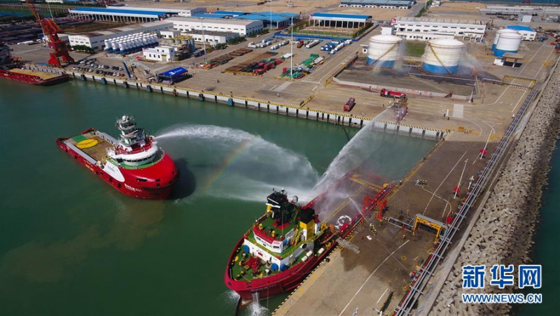 6月12日,在海口港马村港区危险品船舶船岸应急联合演习现场,工作船和消防车赶到现场后实施灭火救援,同时油库启动罐区喷淋给柴油罐降温(无人机照片)。 当日,海口海事局在海口港马村港区组织开展危险品船舶船岸应急联合演练。本次演练通过模拟设置一艘危险品船舶在码头作业过程中发生泄漏事故导致海域污染、船舶起火、人员受伤的场景,演练危险品码头及相关单位部门的应急处置与协作反应,提升危险品码头应急处置能力。 新华社记者 杨冠宇 摄