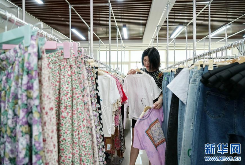 6月5日，河北省辛集市一家服装生产企业的主播在挑选服装，用于网上直播。 今年以来，为帮助企业打破销售瓶颈，拓展更大的发展空间，河北省辛集市启动大型电商直播基地建设项目，按照“政府引导、企业运作、第三方平台支持”的发展模式，为当地企业提供专业直播销售和培训服务，推动线上销售产业发展。 新华社记者 牟宇 摄