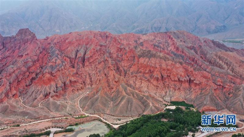 这是6月15日拍摄的位于贵德县境内的丹霞地貌(无人机照片)。 夏日时节,位于青海省海南藏族自治州的贵德县迎来连日降雨,多彩的丹霞地貌在雨后色泽愈发鲜艳,在云雾的笼罩下形成一幅幅独特画卷。 新华社记者 吴刚 摄