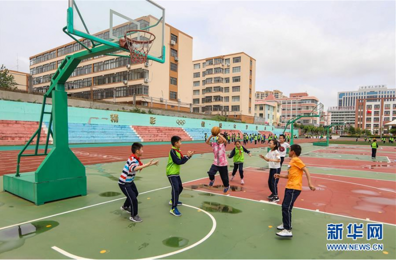6月2日，在山东省荣成市第二实验小学，小学生们在球场上打篮球。 伴随着学生们的返校复课，各地中小学幼儿园的操场又热闹起来。学校在做好防控措施的同时，保证学生们的体育锻炼时间，引导学生恢复体能、放松心情。 新华社发（李信君 摄）