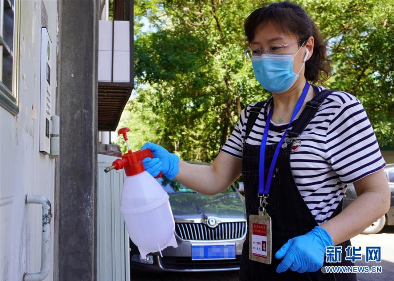 6月15日,丰台区东高地街道干部在辖区内居民楼进行环境消毒工作。新华社记者 李欣 摄