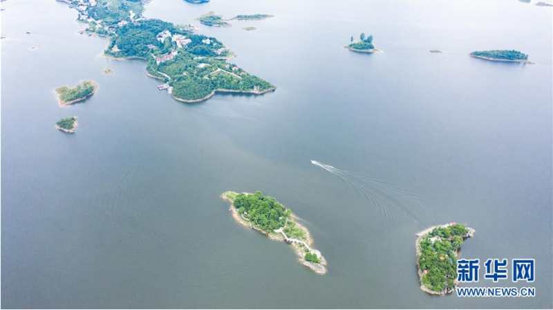 6月21日，游客乘船在红枫湖景区游览（无人机照片）。 夏至时节，贵州省清镇市红枫湖景区草木苍翠，秀丽的湖光山色吸引不少游客前来游玩。 新华社记者 陶亮 摄