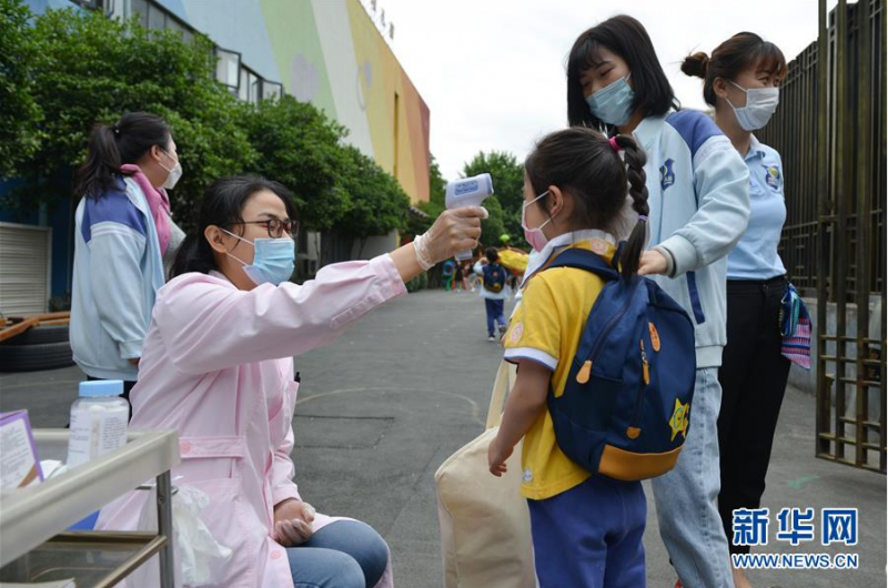 5月25日，在南京市建邺区金地名京幼儿园，工作人员在为小朋友测温。 当日，江苏省南京市幼儿园大班开始返园复学。 新华社发（方东旭 摄）