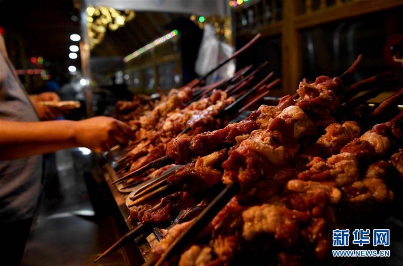 在新疆于田县兰干乡兰干夜市，游客在选购小吃（5月20日摄）。 新华社记者 沙达提 摄