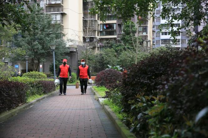 3月2日，在重慶市北碚區(qū)紅桂林小區(qū)，兩名志愿者提著打包好的火鍋套餐走在送給醫(yī)護人員家屬的路上。