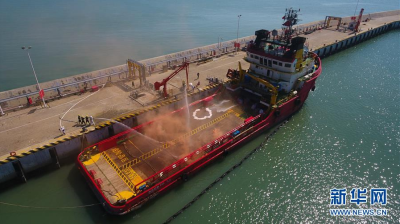 6月12日,在海口港马村港区危险品船舶船岸应急联合演习现场,消防人员在处理船上的“火情”(无人机照片)。 当日,海口海事局在海口港马村港区组织开展危险品船舶船岸应急联合演练。本次演练通过模拟设置一艘危险品船舶在码头作业过程中发生泄漏事故导致海域污染、船舶起火、人员受伤的场景,演练危险品码头及相关单位部门的应急处置与协作反应,提升危险品码头应急处置能力。 新华社记者 杨冠宇 摄