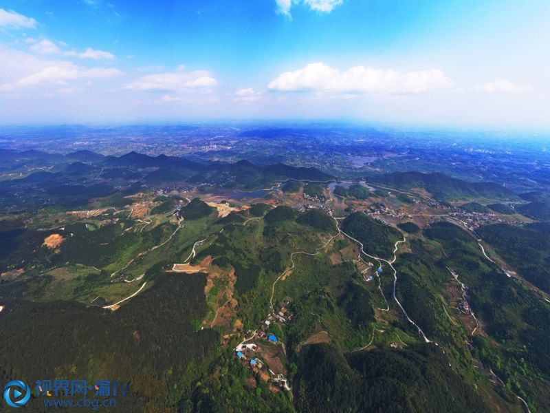 春日的重庆市长寿区五华山景区，满目皆是绿。站在山巅远眺，林中道路蜿蜒向前，大小山丘错落有致，蓝天白云尽收眼底，吸引不少游客前往踏青。摄影 袁志龙