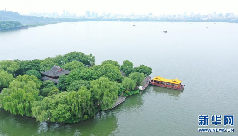 5月27日，船只在西湖湖心亭靠岸（无人机照片）。 随着气温升高，杭州西湖绿意葱茏，展现出柔美的湖光山色。 新华社记者翁忻旸摄