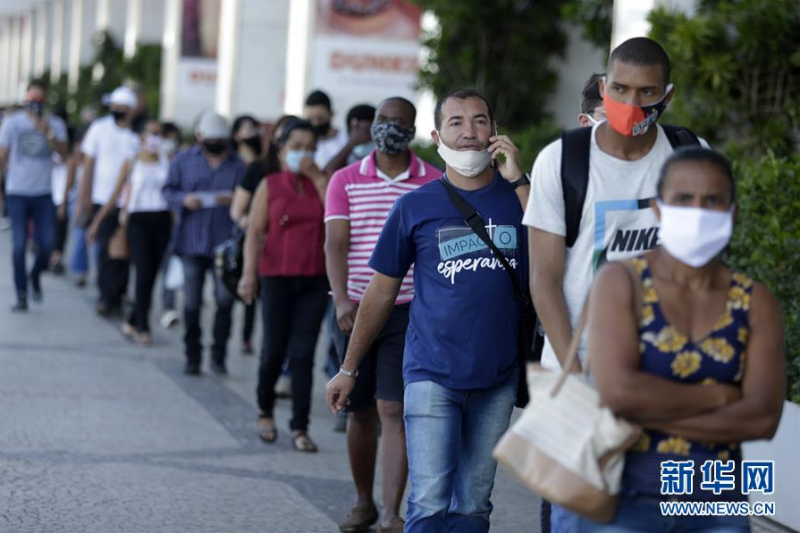 5月27日，在巴西首都巴西利亚，顾客在恢复营业的商场外排队等待检测体温。 据巴西卫生部新冠疫情最新统计数据，截至当地时间27日19时，巴西24小时内新增确诊病例20599例，累计确诊411821例。 新华社发（卢西奥·塔沃拉摄）