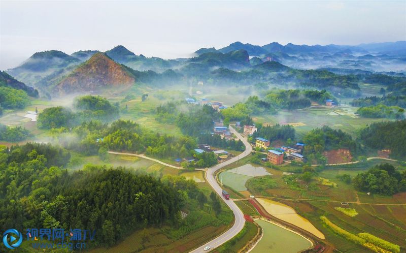 依稀晨霧漂浮山巒，蜿蜒公路穿梭山間。攝影：熊偉