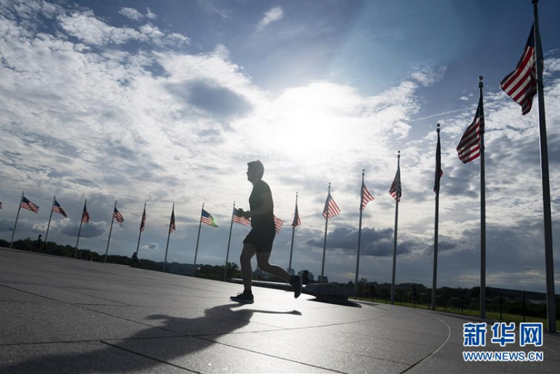 5月27日,一名男子在美国首都华盛顿的国家广场跑步。 美国首都华盛顿市市长缪里尔·鲍泽27日宣布,该市因新冠疫情实施的“居家令”将于29日开始逐步解除。 新华社记者 刘杰 摄