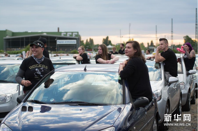 6月13日,观众在德国波恩市坐在车上观看汽车音乐会。新华社发(唐颖摄)