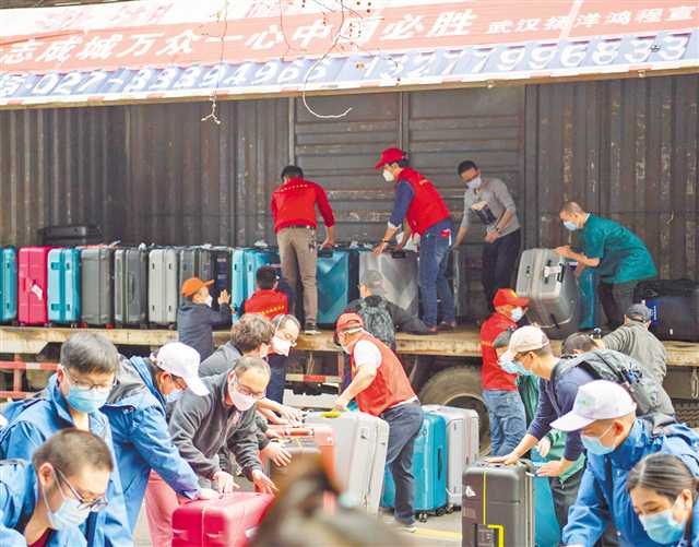 3月21日，武漢市硚口區(qū)，重慶市第八批支援湖北醫(yī)療隊隊員正在有序傳遞行李。