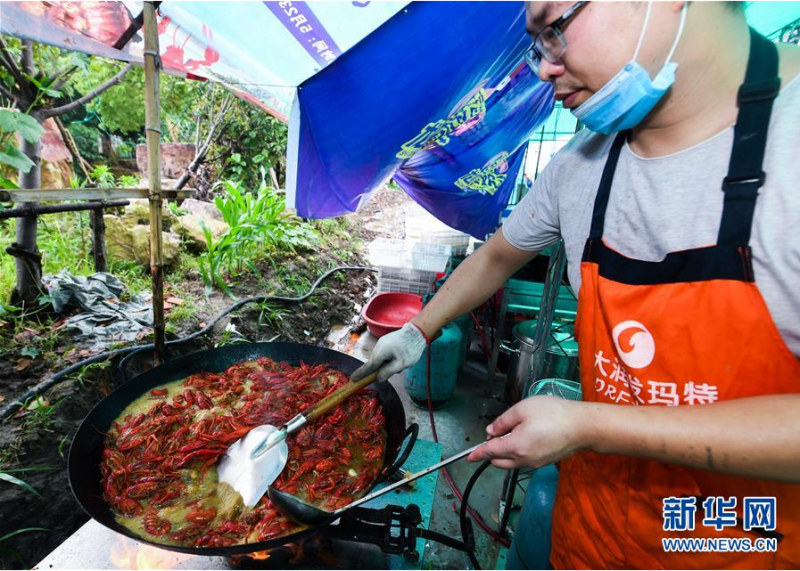 5月30日，厨师在龙虾狂欢节现场烹制小龙虾。新华社记者 徐昱 摄