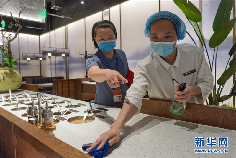 6月15日,丰台区东高地街道干部(左)在检查辖区内餐饮企业环境消毒工作。 当日,北京市丰台区各街道、社区、企事业单位、商业单位全面开展清洁公共环境工作,街道干部下沉到社区,参与和检查社区防控、卫生清洁等工作。 新华社记者 李欣 摄