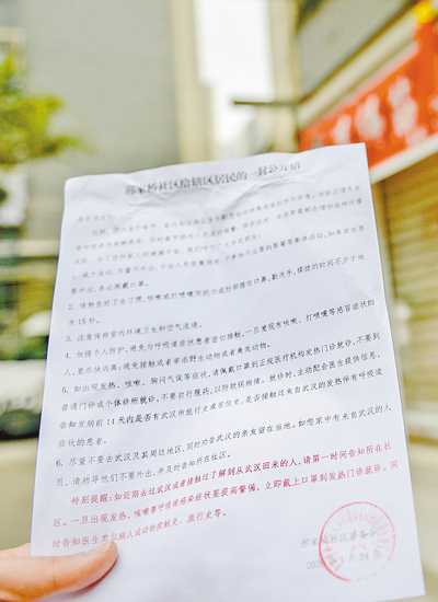 1月24日，在兩江新區(qū)人和街道，社區(qū)工作人員正在挨家挨戶張貼自制的《致社區(qū)居民的一封公開信》，進行防疫宣傳。