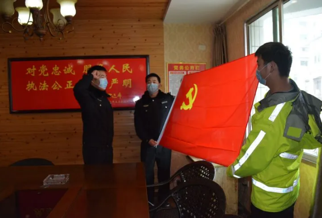 钟仁骏（左一）向党旗举起右手