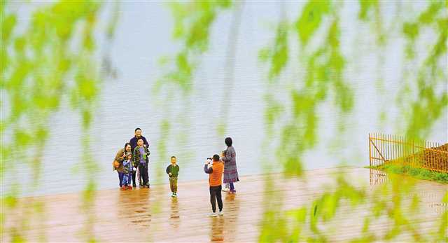   4月5日,巴南木洞古鎮(zhèn),市民在長江邊拍照玩耍。當(dāng)日是清明小長假第二天,重慶春雨綿綿,但擋不住市民踏青訪友游玩的好興致。特約攝影 鐘志兵