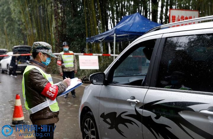 雨雪交加，梁平區(qū)蟠龍鎮(zhèn)疫情防控卡點，工作人員在對過往車輛登記檢查。