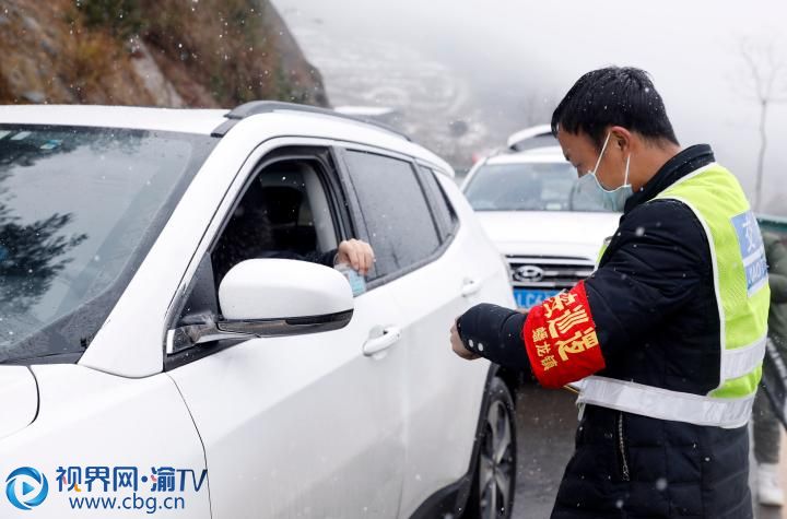 雨雪交加，梁平區(qū)蟠龍鎮(zhèn)疫情防控卡點，工作人員在對過往車輛登記檢查。