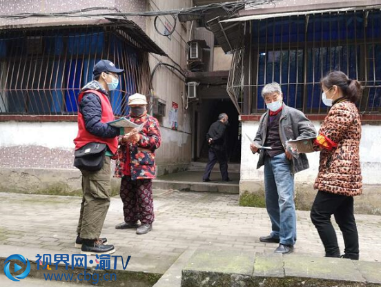 杨坤梅和儿子一起为居民发放防疫知识宣传手册。