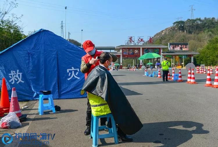 2月12日，重庆三环高速綦江南收费站，在綦江城区开理发店的志愿者王云正在防疫检查站边上为一线奋战多日的工作者们理发。