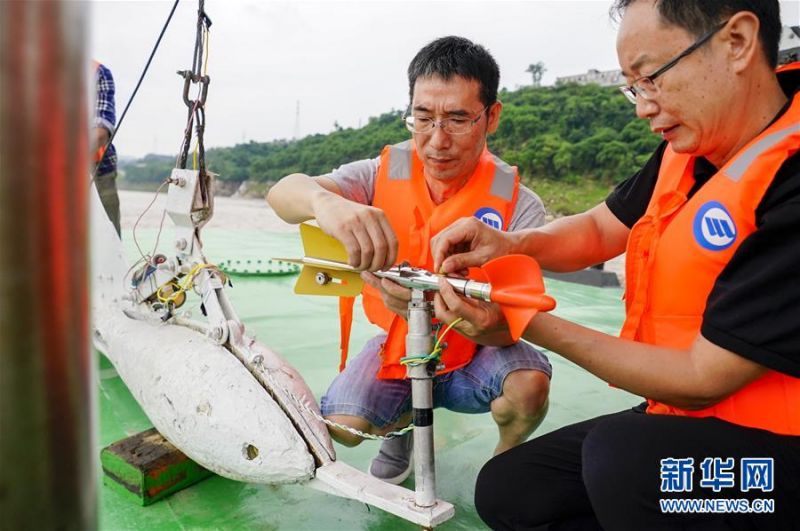 　　7月2日，长江清溪场水文站站长朱辉（左）和同事将流速测量仪器安装在铅鱼上。新华社记者 刘潺 摄